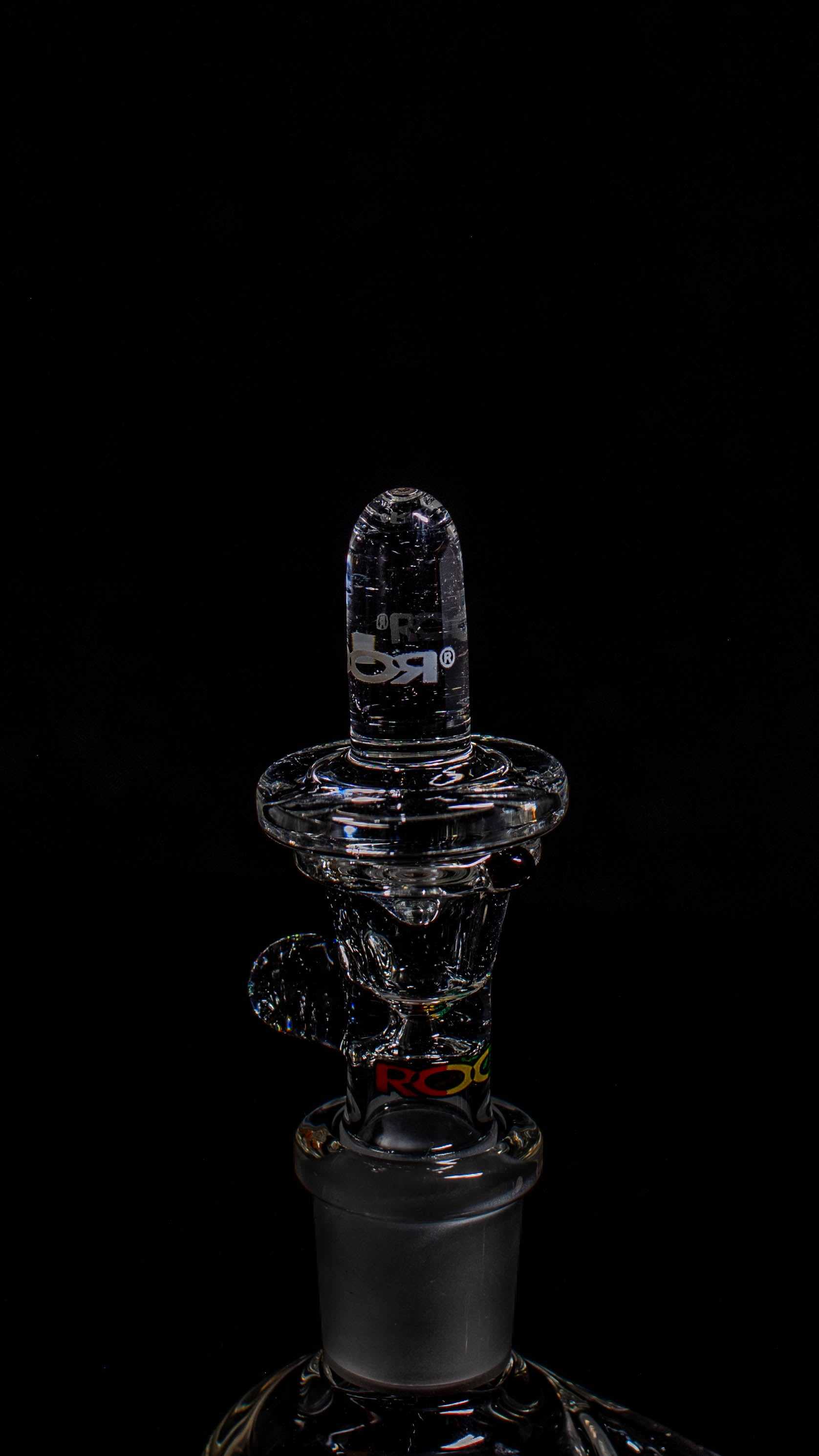 Glass bottle stopper with a reflective surface on a black background