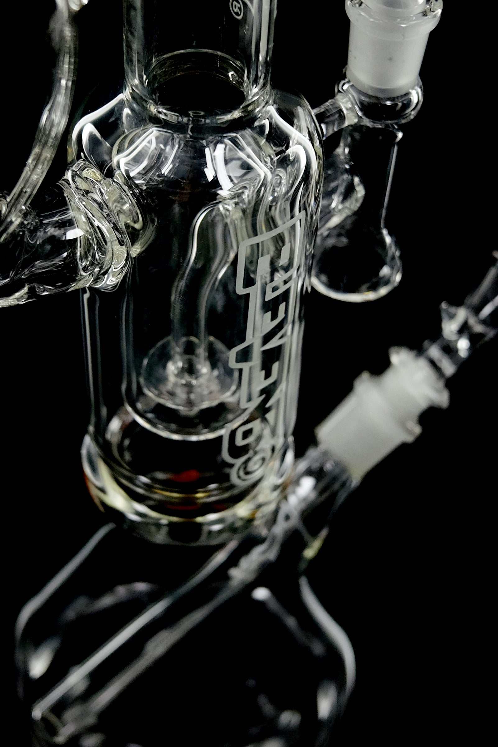Close-up of clear ROOR 1130 Mini Beaker glass water pipe with detailed joints and percolator on black background