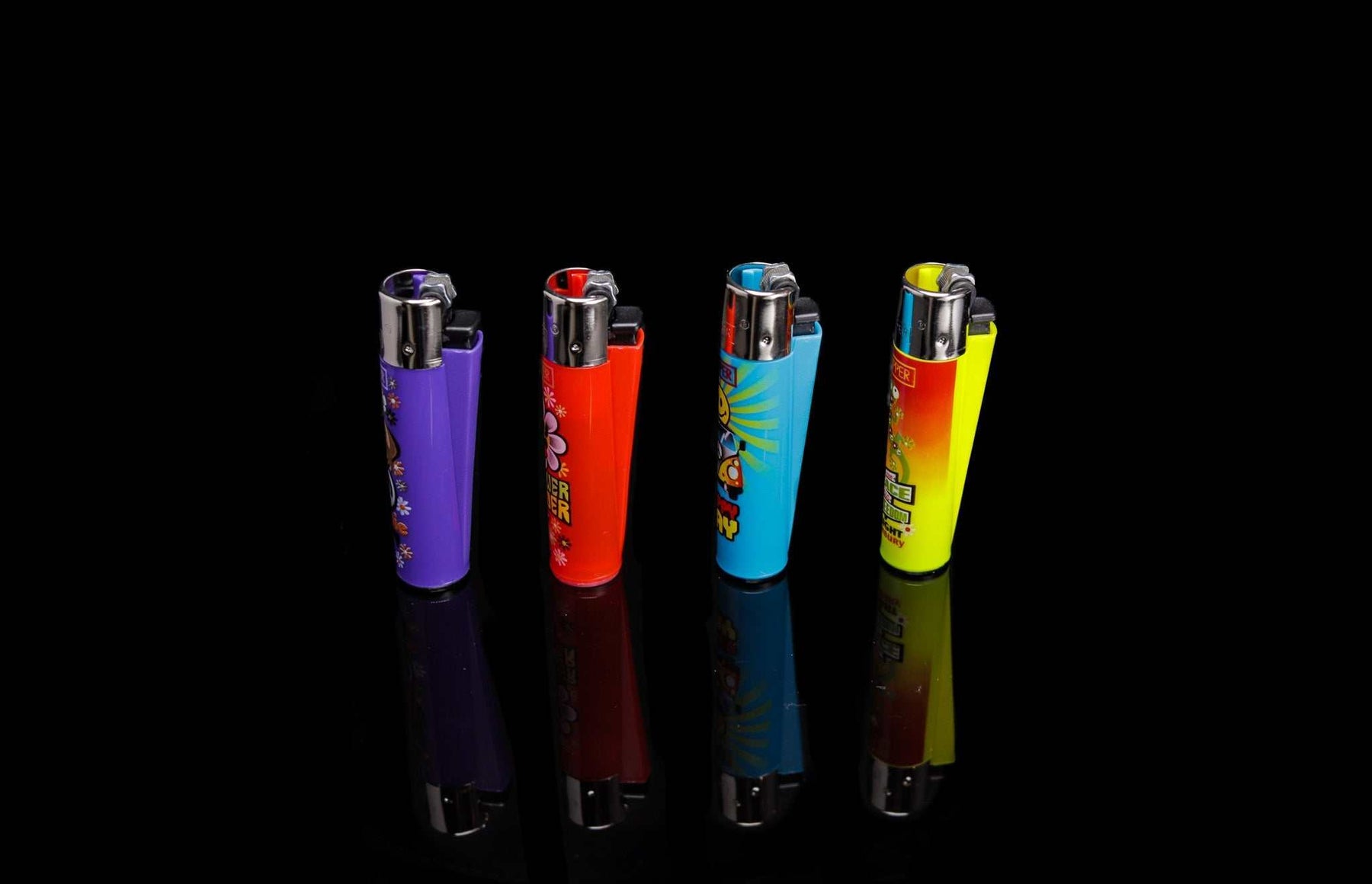 Set of four colorful Clipper lighters with hippie-themed peace and freedom designs on black background