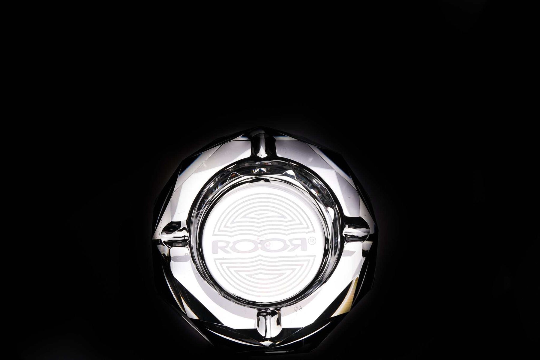 Clear ROOR Glass Crystal Cut Ashtray with hand-cut facets and engraved logo on black background