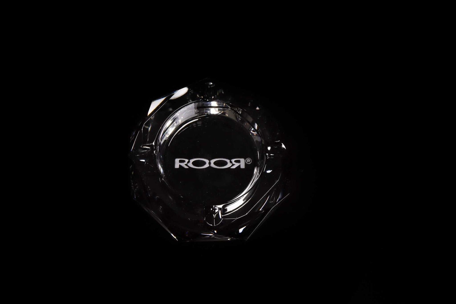 ROOR Glass Crystal Cut Ashtray with engraved logo on clear faceted crystal design on black background