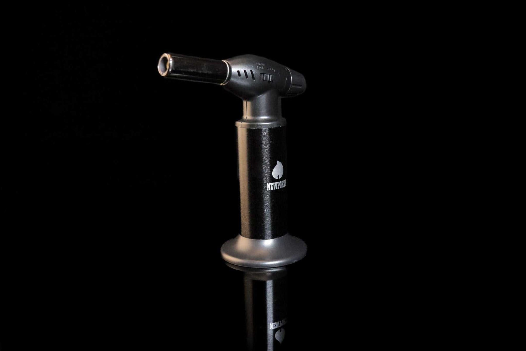 Black Newport Zero Jumbo butane torch with ergonomic handle on black reflective surface