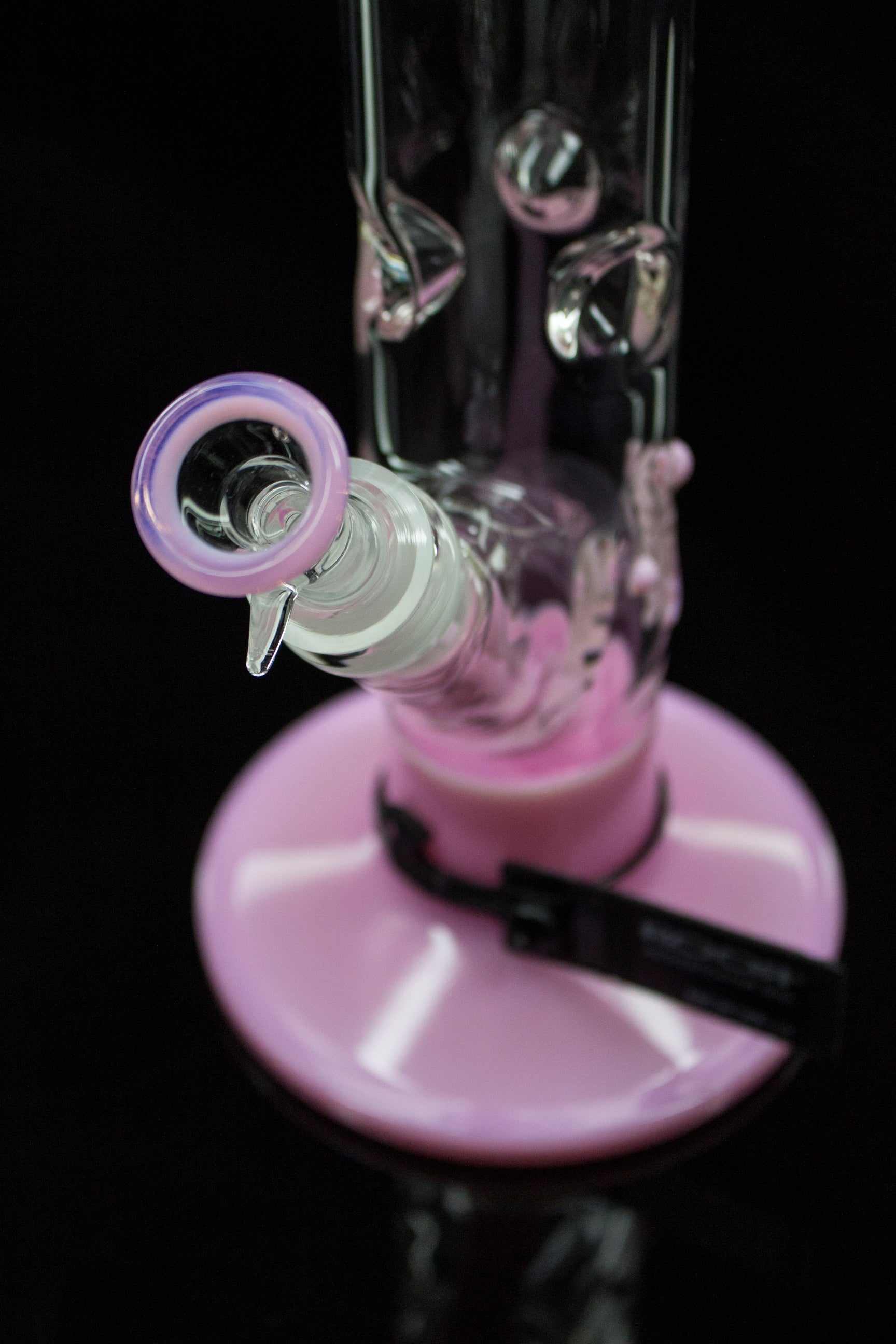 Close-up of ROOR® Classic 14" Color Straight 50x5mm Pink glass bong with ice pinches and pink base on black background