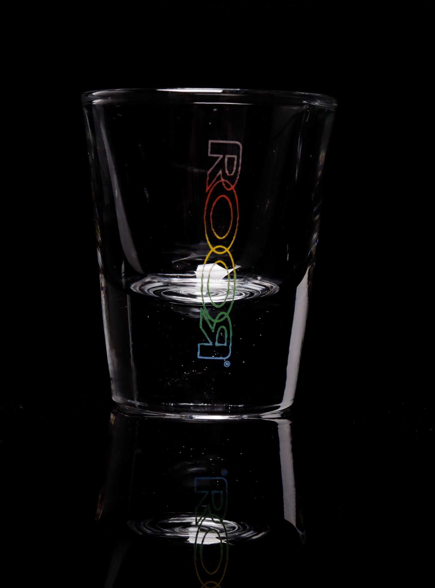 ROOR Shot Glass with thick clear base and colorful decal on black background.