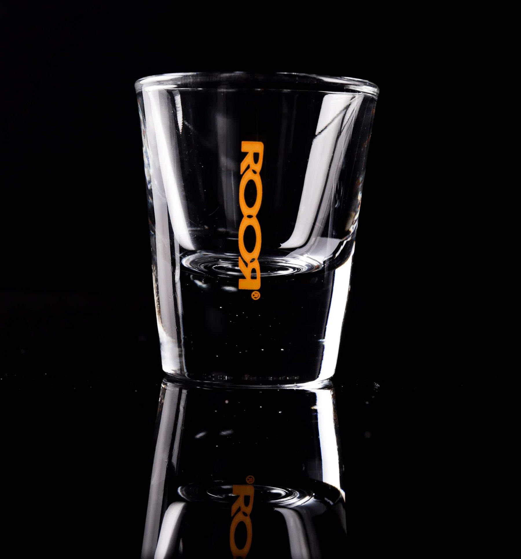ROOR Shot Glass with thick clear base and orange decal.