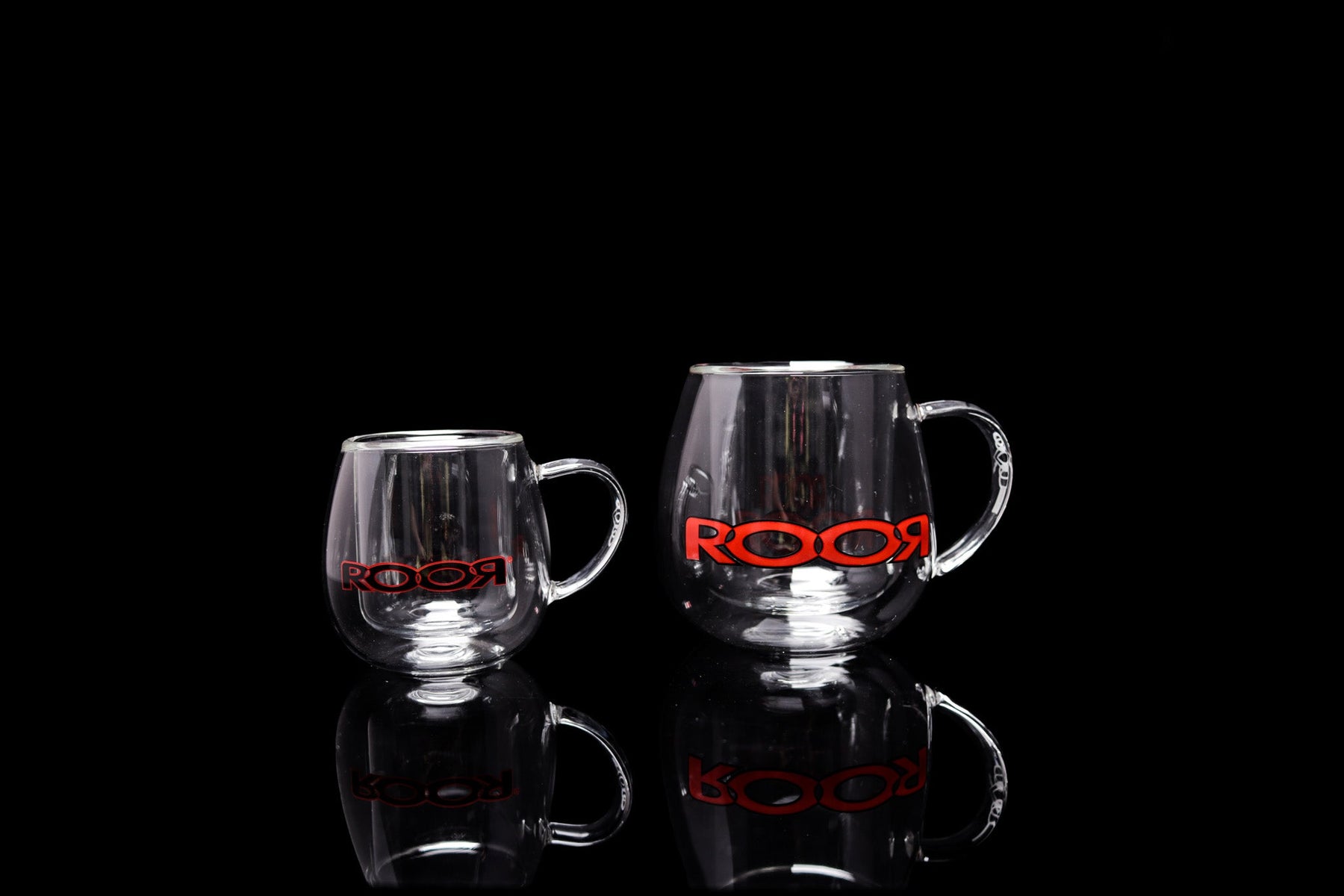 ROOR® Glass Mugs Double Layer with red logo on reflective black surface.